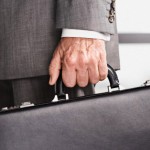 Close up of businessman's hand carrying briefcase